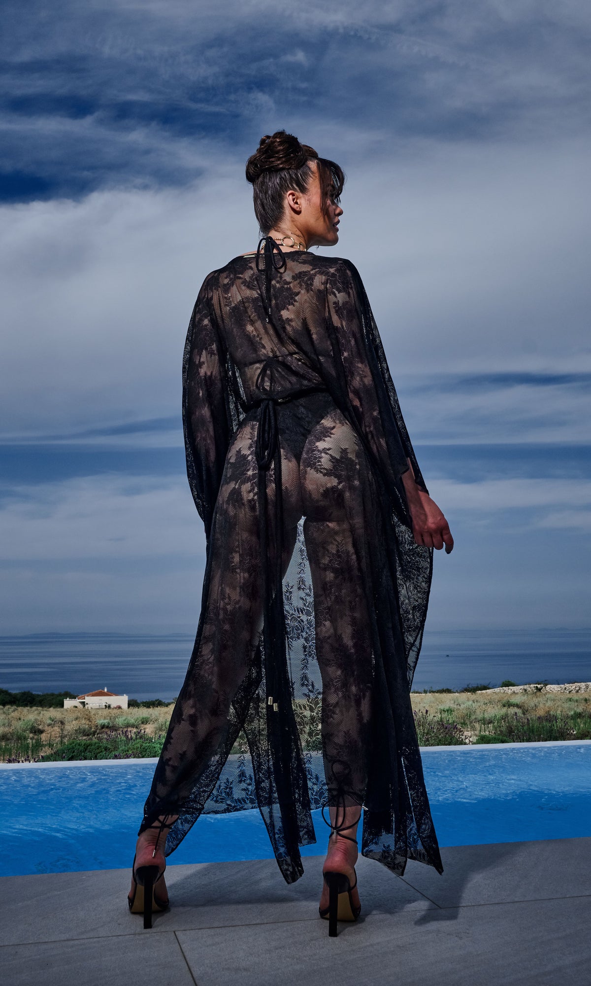 Luxury sustainable lace cover-up by Antoninias from the Flora collection, featuring sheer floral fabric, flowy silhouette, and a gold-tone belt, ideal for premium resort wear and designer womenswear.