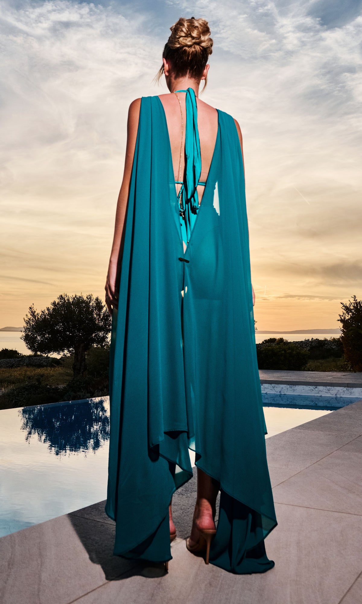 Luxury Clementine beach coverup in petrol by Antoninias, crafted with lightweight fabric and gold-tone accents for an elevated summer style.