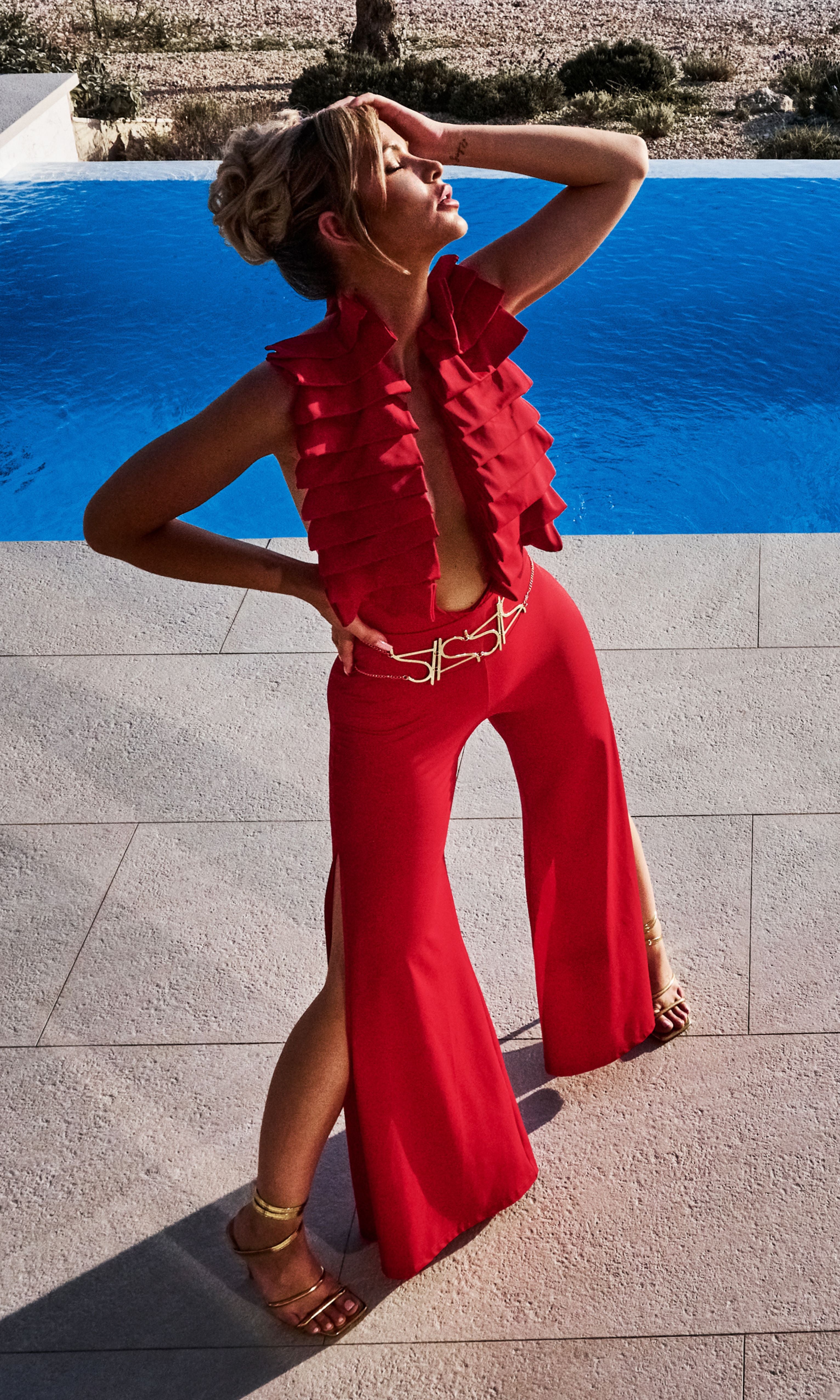 Luxury sustainable red Cleo pants by Antoninias, designed with a high-waisted fit, dramatic front slits, and a flowing silhouette, perfect for premium resort wear and designer womenswear.